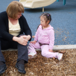 Teaching and student sitting and talking in playground